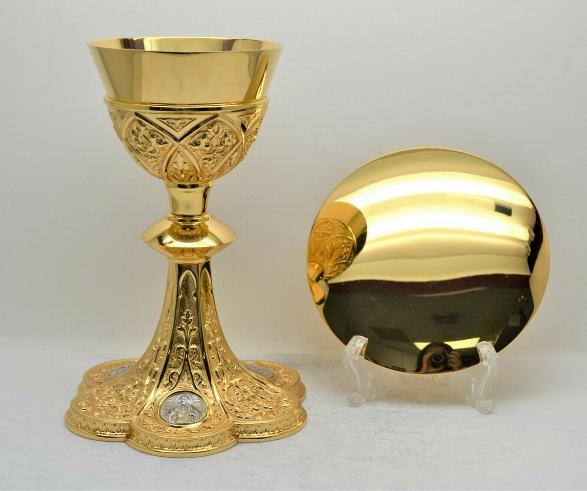 Gold chalice with an engraved cup, knop and base, beside a gold paten on a stand