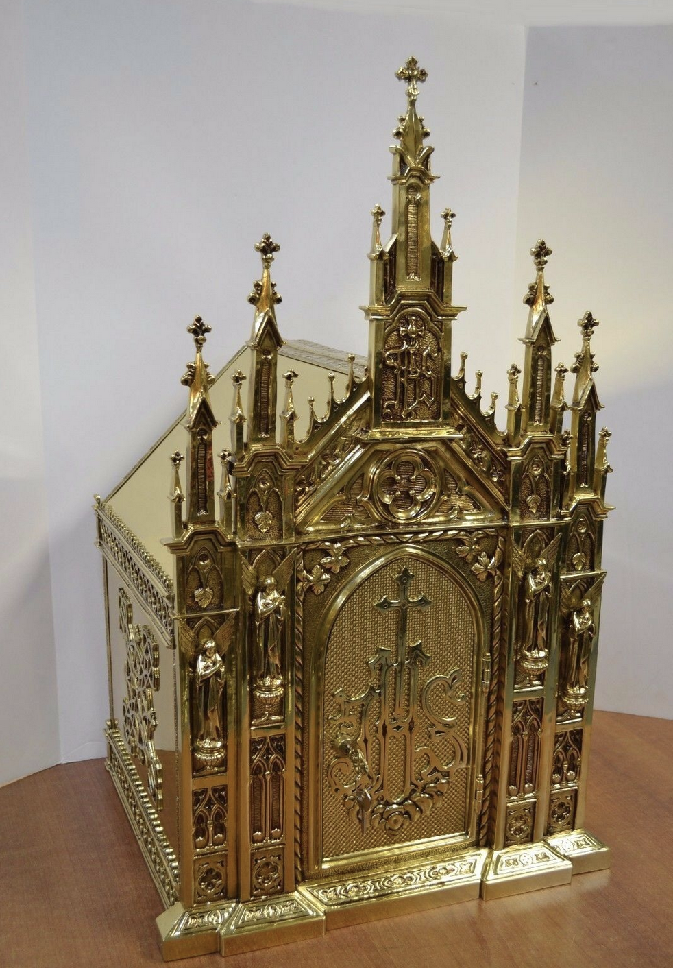 Gothic brass tabernacle with tall spires and a cross on the door